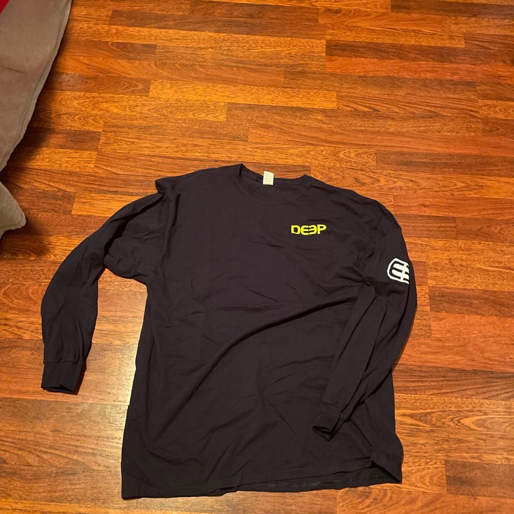 deep yellow corner logo with arm logo in white long sleeve shirt